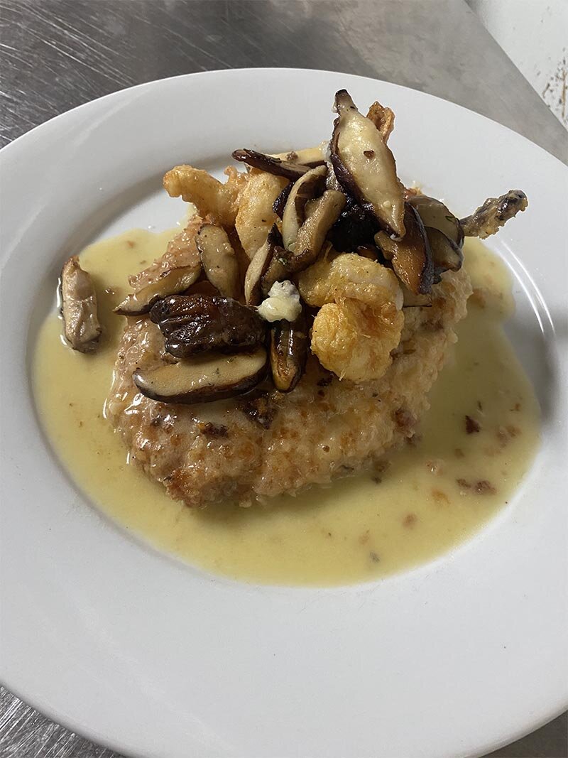 Fried veal topped with mushrooms in a white sauce