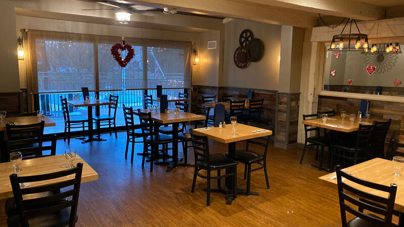 Fireplace room with many set tables and view of outside