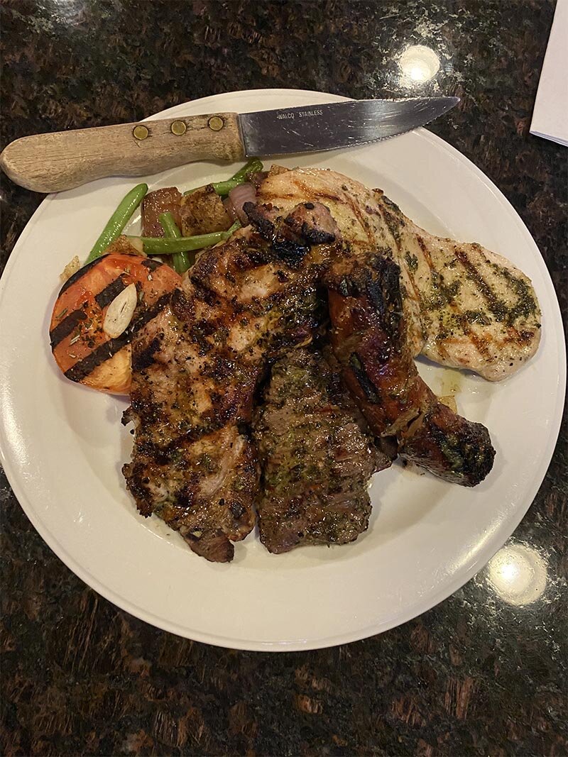 Steak, chicken and sausage with a side of tomato and green beans