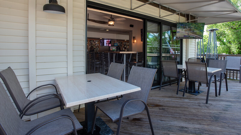 Patio dining area with view of interior bar area