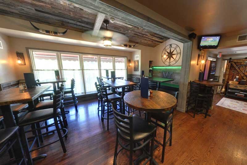 Bar seating area with high-top tables and chairs