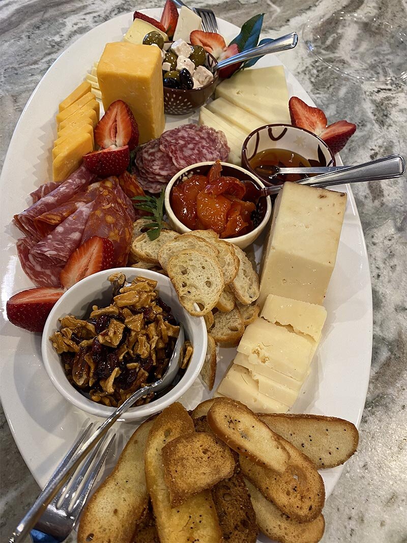 Charcuterie board with a variety of cheeses, spreads and bread